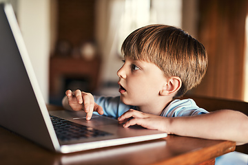 Image showing Immersed in media. Shot of an adorable little boy using a laptop at home.