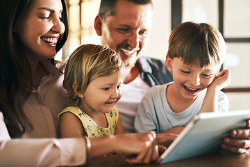 Image showing Adding screen time to family time. Shot of a young family of four using a digital tablet together at home.