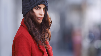 Image showing When in doubt wear red. Shot of a beautiful young woman in winter clothing standing in an urban setting.