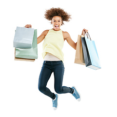 Image showing Shopping spree frenzy. Studio portrait of an excited young woman carrying shopping bags and jumping for joy against a white background.