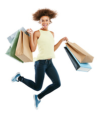 Image showing Payday delight. Studio portrait of an excited young woman carrying shopping bags and jumping for joy against a white background.