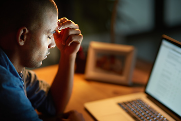 Image showing The long hours are getting to him. Cropped shot of a young businessman looking stressed out while working late in an office.