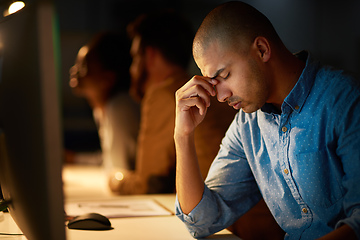 Image showing When will I see the end of this.... Cropped shot of a young businessman looking stressed out while working late in an office.