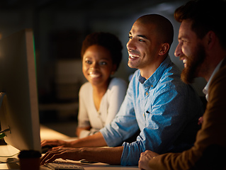 Image showing Making easy work of overtime as a team. Cropped shot of a group of colleagues working late in an office.