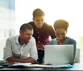 Image showing Working together to get ahead. Cropped shot of a group of colleagues working together on a laptop in an office.