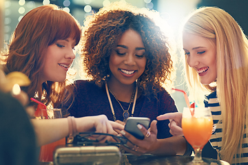 Image showing Deciding which selfie to share. Shot of a group of happy friends enjoying cocktails in a nightclub.