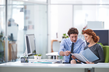 Image showing Together they will get the job done. Young business professionals discussing work documents.