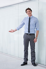 Image showing Welcome to our office. Full length shot of a young businessman gesturing with his arm.