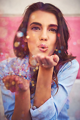 Image showing Be the sparkle you want to see. Portrait of a beautiful young woman blowing confetti outside.