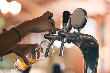 Image showing Pouring the first one of the day. Shot of an unrecognizable person pouring a beer from a tap inside of a beer brewery during the day.