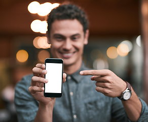 Image showing Looks like were getting popular. Shot of a confident young man holding up a cellphone to the camera while standing inside of a beer brewery during the day.