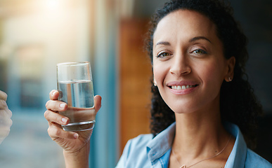 Image showing Working on my daily water goal. Portrait of a woman drinking a glass of water at home.