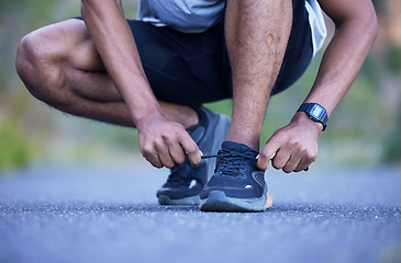 Image showing Fitness, exercise and a man tying shoelace outdoor for run, workout or training performance. Closeup of athlete person or runner with running shoes on a road for cardio or health and wellness