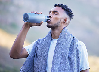 Image showing Fitness, exercise and a man drinking water outdoor on a break or rest after run, workout or training. Tired athlete person or runner in nature with a bottle for thirst, cardio or health and wellness