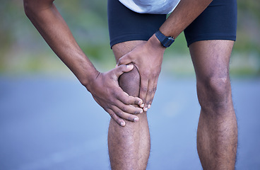 Image showing Fitness, running and man in road with knee pain, sports cramp stop and workout on path. Outdoor exercise, health and wellness, runner and hand on leg injury for massage relief while marathon training