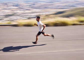 Image showing Fitness, running and motion blur with a sports man on a road for his cardio or endurance workout. Exercise, health and a runner training for a marathon or challenge in the mountains during summer