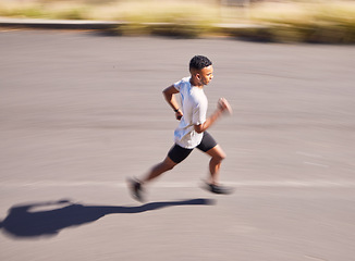 Image showing Health, running and motion blur with a sports man on a road for his cardio or endurance workout from above. Exercise, fitness and a runner training for a marathon in the mountains during summer