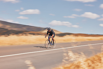 Image showing Road, nature and man cycling fast for workout, exercise and scenic mountain path with motion. Health, wellness and cyclist on speed bike for morning training, practice and bicycle race with blue sky.
