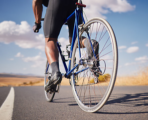 Image showing Road, closeup and man on a bike for cycling, race training or travel in the countryside. Health, exercise and legs of male cyclist or athlete with a bicycle for a workout, street cardio or triathlon