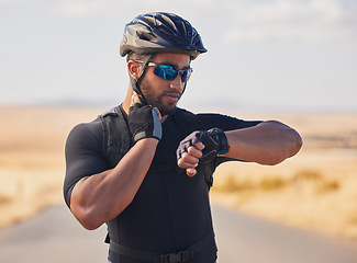 Image showing Fitness, cycling and man checking pulse at race, marathon or competition training in nature. Sports, workout and young male athlete timing his heart rate for health at an outdoor cardio exercise.