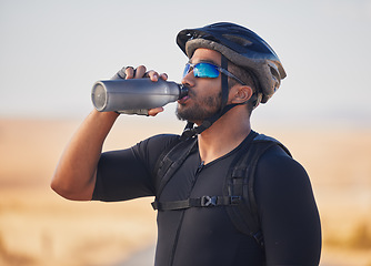 Image showing Fitness, health and man cyclist drinking water at race, marathon or competition training. Sports, workout and thirsty male athlete with hydration for wellness at an outdoor cardio exercise in nature.