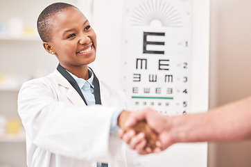 Image showing Optometrist woman, handshake and smile with patient, customer and happy for agreement, deal or sale. African ophthalmology doctor, shaking hands and kindness for healthy eyes, wellness or healthcare