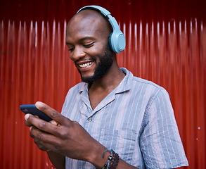 Image showing Black man, smartphone and headphones, smile with technology and listening to music or podcast. Communication, social media and online chat, audio streaming and subscription with network and gen z