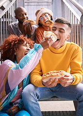 Image showing Friends, city and feeding food outdoor for happiness, funny laugh and fun on stairs. Diversity, eating and gen z group of men and women with a hotdog on a date, adventure and freedom in urban town