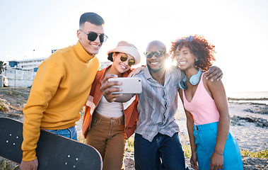 Image showing Selfie, smile and group of friends by the beach on summer vacation, adventure or weekend trip. Happy, diversity and young people having fun with skateboard and taking picture by the ocean on holiday.