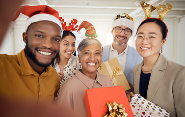 Image showing Business people, Christmas selfie and group with smile, present or portrait for celebration, diversity or party. Men, women and photography for xmas memory, friends and gift box for workplace culture