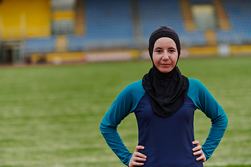 Image showing A Muslim woman with a burqa, an Islamic sportswoman resting after a vigorous training session on the marathon course. A hijab woman is preparing for a marathon competition