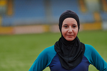 Image showing A Muslim woman with a burqa, an Islamic sportswoman resting after a vigorous training session on the marathon course. A hijab woman is preparing for a marathon competition