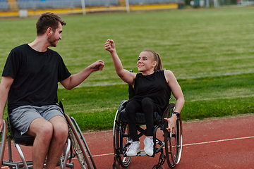 Image showing A woman with disability in a wheelchair talking with friend after training on the marathon course