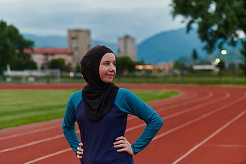 Image showing A Muslim woman with a burqa, an Islamic sportswoman resting after a vigorous training session on the marathon course. A hijab woman is preparing for a marathon competition