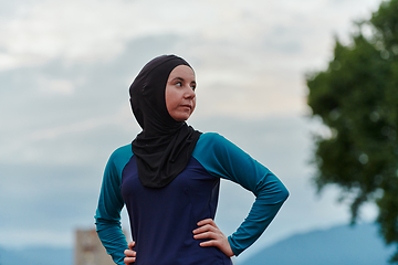 Image showing A Muslim woman with a burqa, an Islamic sportswoman resting after a vigorous training session on the marathon course. A hijab woman is preparing for a marathon competition