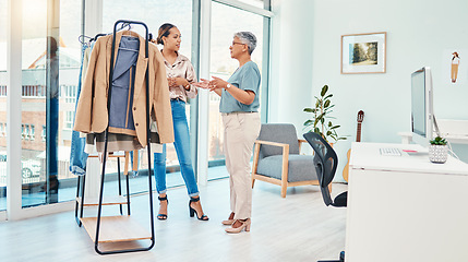 Image showing Fashion designer, teamwork or women planning clothes fabric in small business together in collaboration. Leader, rack or stylist consulting a mature mentor for advice or help on project in internship