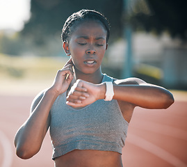 Image showing Time, pulse and exercise with a woman outdoor on a track for running, training or workout. African athlete person at stadium for goals, fitness and body wellness with a watch for progress or steps