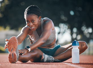 Image showing Sports, stretching and exercise with a woman outdoor on a track for running, training or workout. Happy African athlete person at stadium for legs stretch, fitness and muscle warm up or body wellness