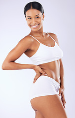 Image showing Portrait, underwear or woman in studio for body health or wellness on white background for diet to lose weight. Self care, smile or happy model with smooth stomach, glow or skin at spa for beauty