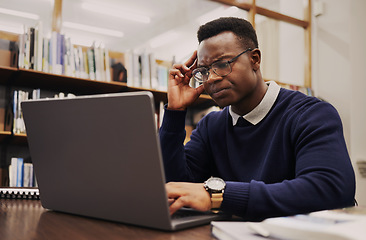 Image showing Man, student and thinking on laptop in library for studying, university research or headache and stress of debt or results. Young and confused african person on computer for education FAQ or question