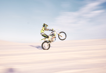 Image showing Bike, speed and balance with a sports man riding a vehicle in the desert for adventure or adrenaline. Motorcycle, training and motion blur with an athlete outdoor in nature for freedom or power