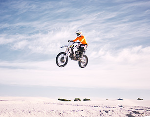 Image showing Bike, speed and jump with a man on sand riding a vehicle in the desert for adventure or adrenaline. Motorcycle, training and freedom with an athlete in the sky in nature for power or competition