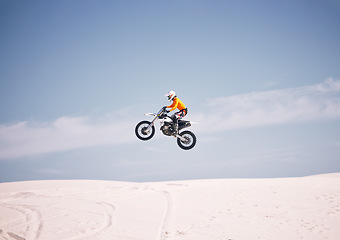 Image showing Motorcycle, mockup and sky with a man in the desert riding a vehicle for adventure or adrenaline. Bike, jump and training with an athlete in the air in nature for freedom, power or active competition