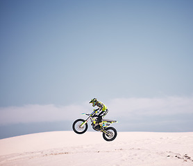 Image showing Bike, sky and jump with a man on mockup riding a vehicle in the desert for adventure or adrenaline. Motorcycle, speed and space with an athlete on sand in nature for freedom, power or competition