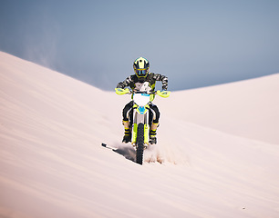 Image showing Dune, motorbike and man athlete training in desert for extreme sports race or competition. Fitness, sand and male biker on hill for dirt biking challenge, stunt or skill for practice with motorcycle.