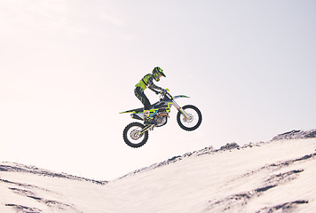 Image showing Bike, sand and jump with a sports man riding a vehicle in the desert for adventure or adrenaline. Motorcycle, training and ramp with an athlete outdoor in nature for freedom, power or competition