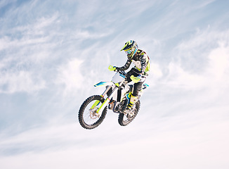 Image showing Blue sky, jump and man on motorbike in air for practice, training and extreme sports energy. Professional dirt biking speed challenge, off road adventure and danger at off road motorcycle competition