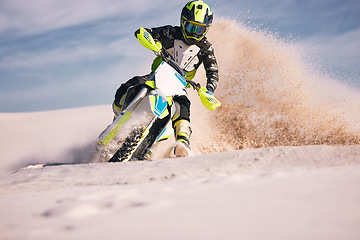 Image showing Motorcycle, dust and energy with a sports man riding a vehicle in the desert for adventure or adrenaline. Bike, freedom and training on sand with an athlete outdoor in nature for power or competition