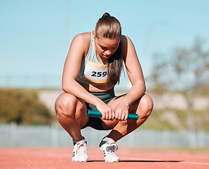 Image showing Fitness, relax and woman athlete on track for a relay race, marathon or competition at a stadium. Sports, workout and young female runner resting with a baton for an outdoor cardio training exercise.