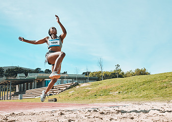 Image showing Athletics, fitness and sports woman doing long jump in outdoor competition, athlete challenge or workout. Agility, sand pit and female person training, exercise and action performance at arena event
